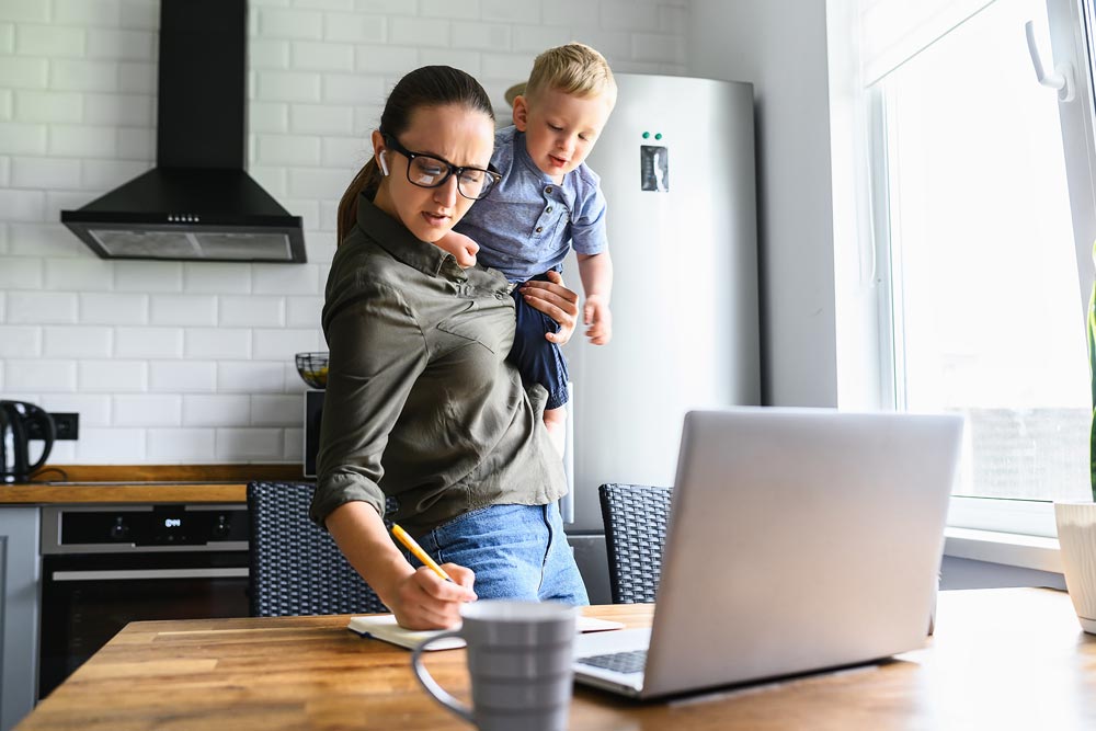 mom holding kid and on laptop. billing assistants