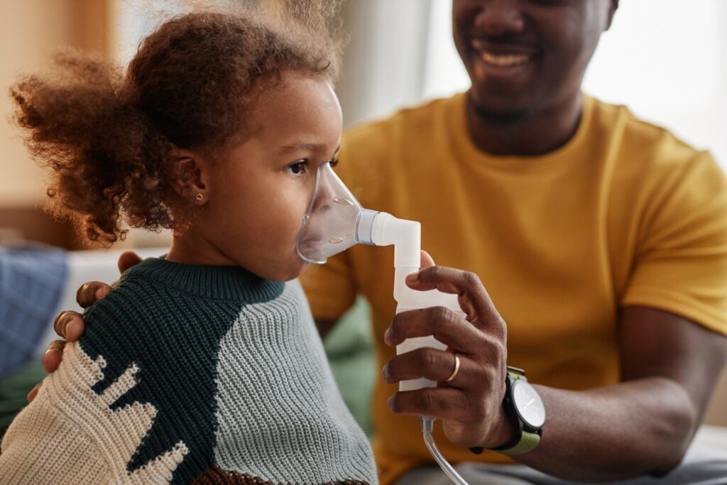 Young girl with asthma is cared for by a parent.