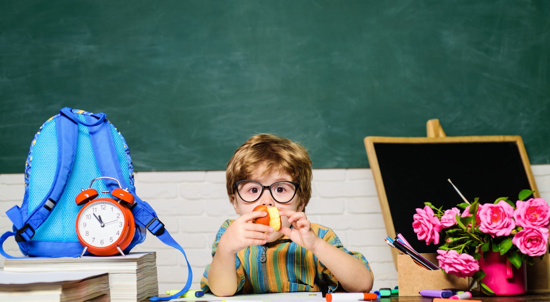 Child eats apple in a school setting.