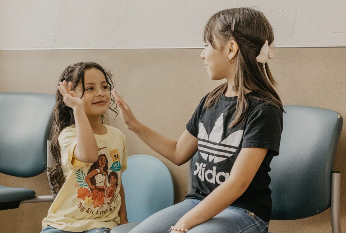 Siblings playing together in waiting room.